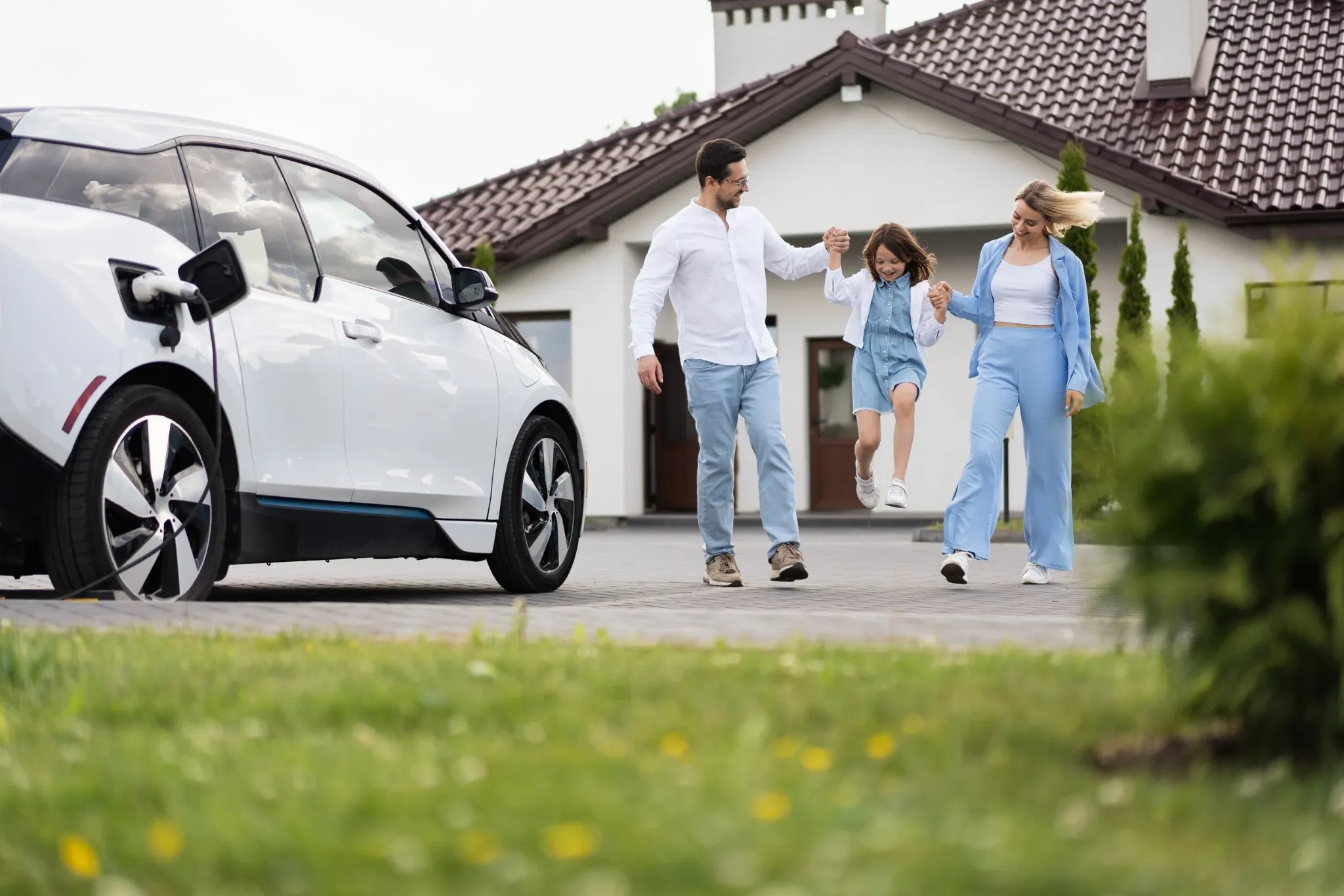 Gezin bij een auto voor een woning
